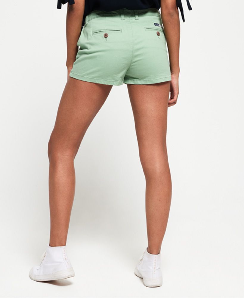 Superdry women's Chino hot shorts. These chino shorts are a perfect addition to your summer wardrobe, featuring a classic four pocket design and zip and button fastening.Completed with a Superdry metal badge on the front and a Superdry logo badge above one back pocket.