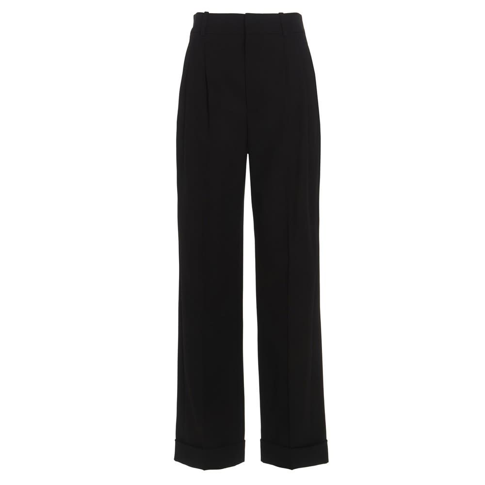 High-waisted wide-leg black trousers in grain de poudre. It features concealed button, hook and zip closure, two side slash pockets, center pleats, two rear welt pockets, upturned hems and belt loops. The model is 180cm tall and wears size 36.  