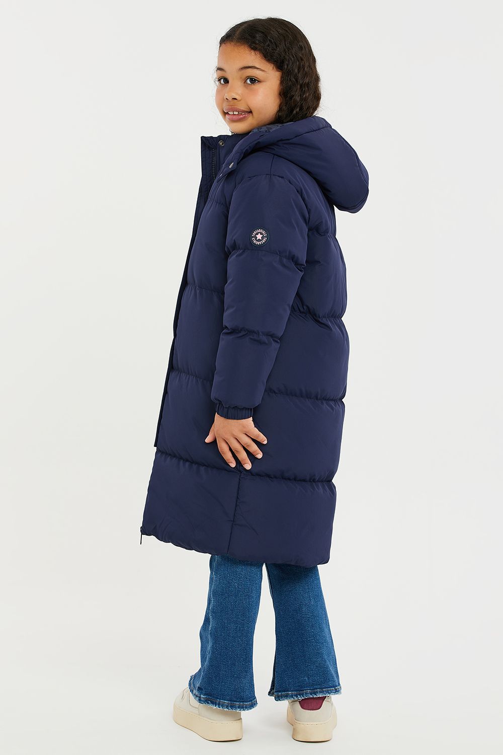 This longline hooded, padded jacket from Threadgirls features a two-way zip and popper fastenings. The jacket also has two side pockets, elasticated cuffs, and branded badge on the sleeve. Perfect for keeping warm this back-to-school season, other colours and styles are also available.