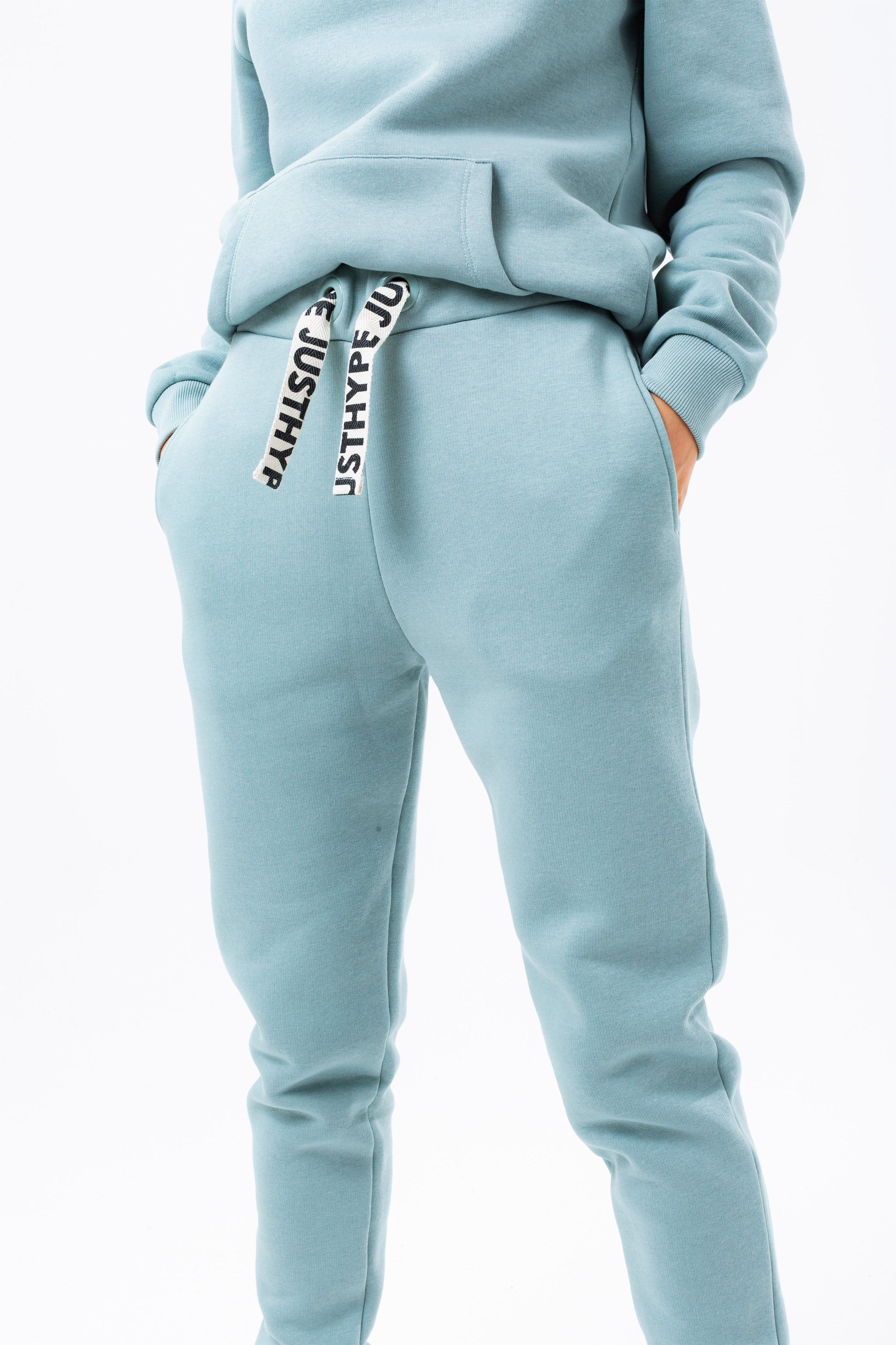 The HYPE. sage drawstring women's joggers are perfectly matched with the HYPE. sage drawstring women's hoodie to complete the look. Or opt for a cute contrasting white crop tee. Designed in 65% cotton and 35% polyester for an unreal amount of comfort. With an elasticated waistband and woven embossed drawstrings, these essential women's joggers are the perfect addition to your jogger 'drobe. Available in UK sizes from 4 to 20. Machine wash at 30 degrees.