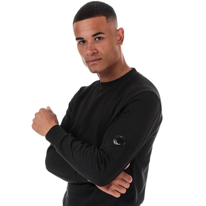 Mens C.P. Company Arm Lens Sweatshirt  Black. <BR><BR>- Long sleeves.<BR>- Crew neckline.<BR>- Features a zipped pocket on the left sleeve.<BR>- Completed with brands signature goggle logo badge lens within the sleeve zip pocket. <BR>- Regular fit.<BR>- 100% cotton. Machine washable.<BR>- Ref: 09CMSS039A999.