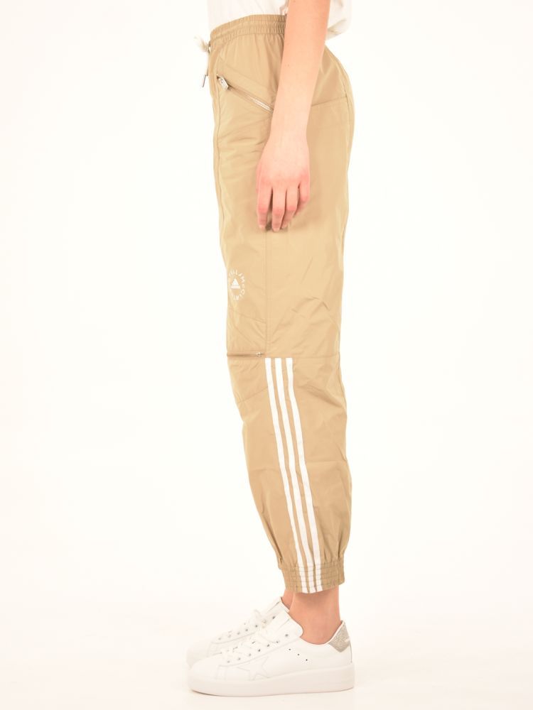 Beige sports trousers with zip at the knees and side pockets with zip. White stripes along the bambe and logo on the front. Elasticated waist and bottom.The model is 183 tall and wears size 38IT