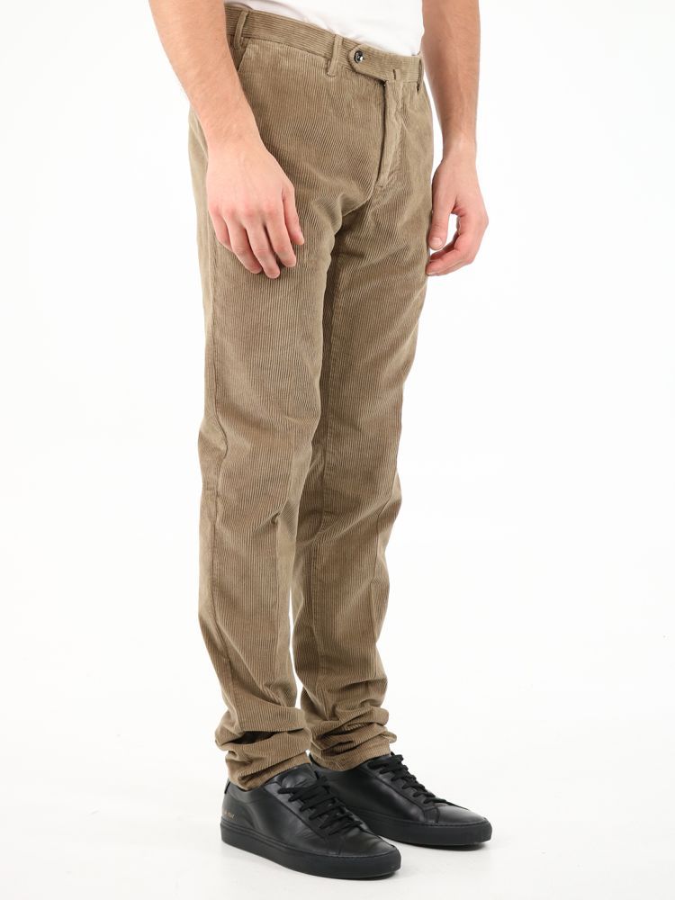 Beige corduroy trousers. They feature front zip and button closure, two side welt pockets, two back pockets with button and belt loops.The model is 184 cm tall and wears a size 48