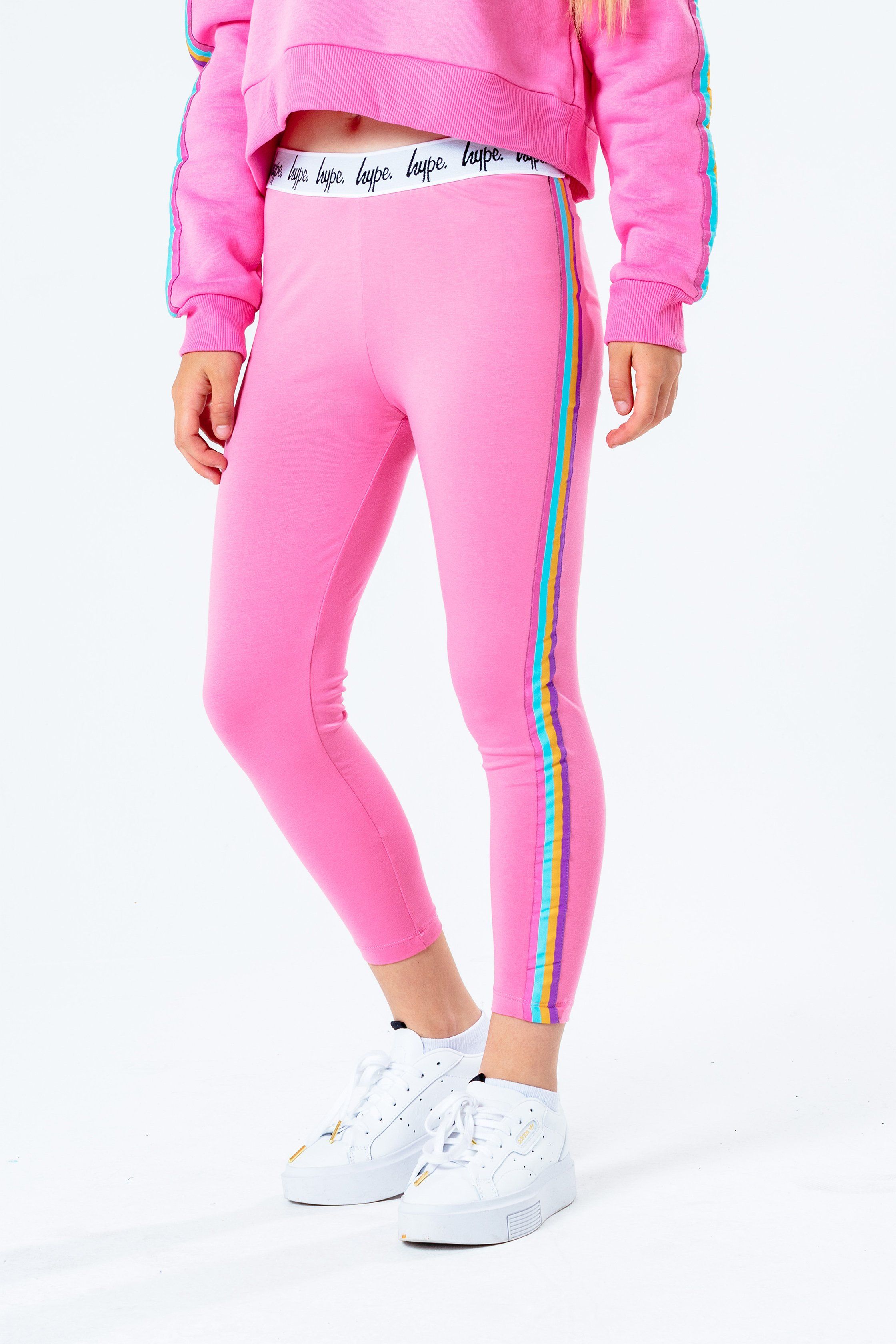 Meet the HYPE. girls pink rainbow leggings, perfect for those who love to make a statement. Designed with a pink base, with rainbow striped side taping, finished with a monochrome embossed elasticated waistband. Mix 'n' match these leggings with any girls t-shirt or hoodie from the rainbow collection. Available in sizes 3-4 years to 16 years. Machine wash at 30 degrees.