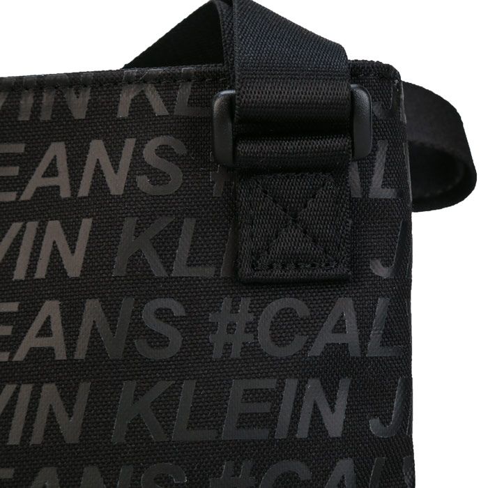 Mens Calvin Klein Sport Essential Cross Body Bag in black.<BR><BR>- All-over tonal Calvin Klein logo.<BR>- Adjustable strap.<BR>- Zip fastening compartments.<BR>- Calvin Klein branded logo patch to the front.<BR>- Branded zip pullers.<BR>- 100% Polyester.<BR>- Ref: K50K5055660GV