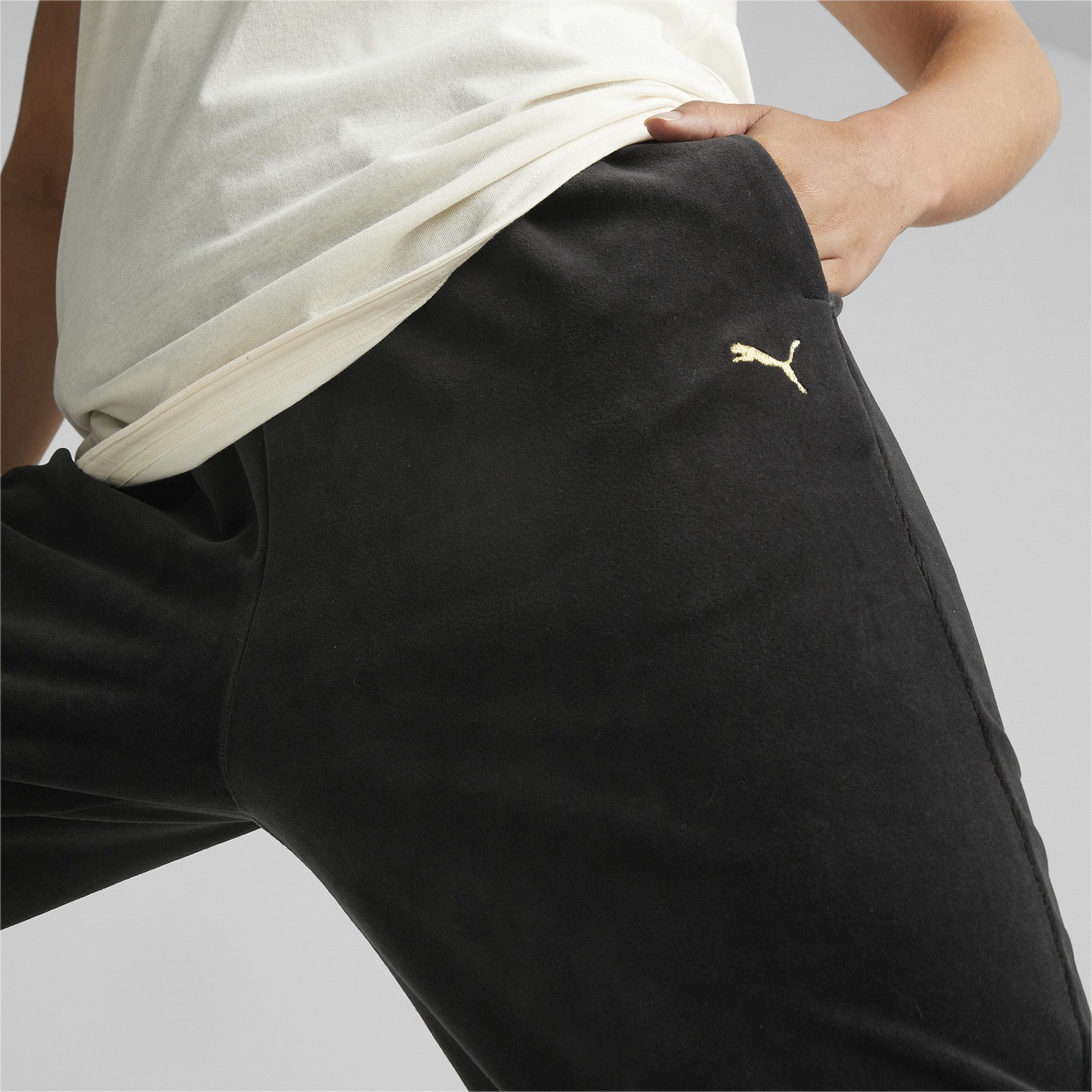 PRODUCT STORY Serve Y2K realness out on the track in the Deco Glam Velour Training Pants. The playful metallic trims inject a bit of sparkle into any training session, while our dryCELL technology is ready to wick away sweat as you get down to business. Hit your personal best in style. FEATURES & BENEFITS : dryCELL: Performance technology designed to wick moisture from the body and keep you free of sweat during exercise DETAILS : Regular fit Elastic waist and cuffs with metallic details Two side seam pockets PUMA Cat Logo on left thigh