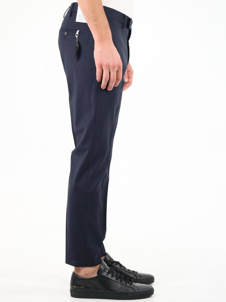 Tailored trousers made of blue wool. They feature zip and hook closure, two side welt pockets, two back pockets with buttons, belt loops and removable feather detail on the back.The model is 184 cm tall and wears a size 48