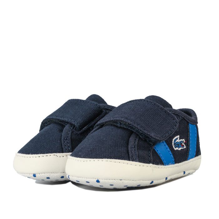 Baby Boys Sideline Crib Trainers – Hook and loop fastening. – Presentation Box. – Soft Sole. – Lacoste Logo to side –Textile Upper – Textile lining – Synthetic sole – Ref: 739CUB00012S3