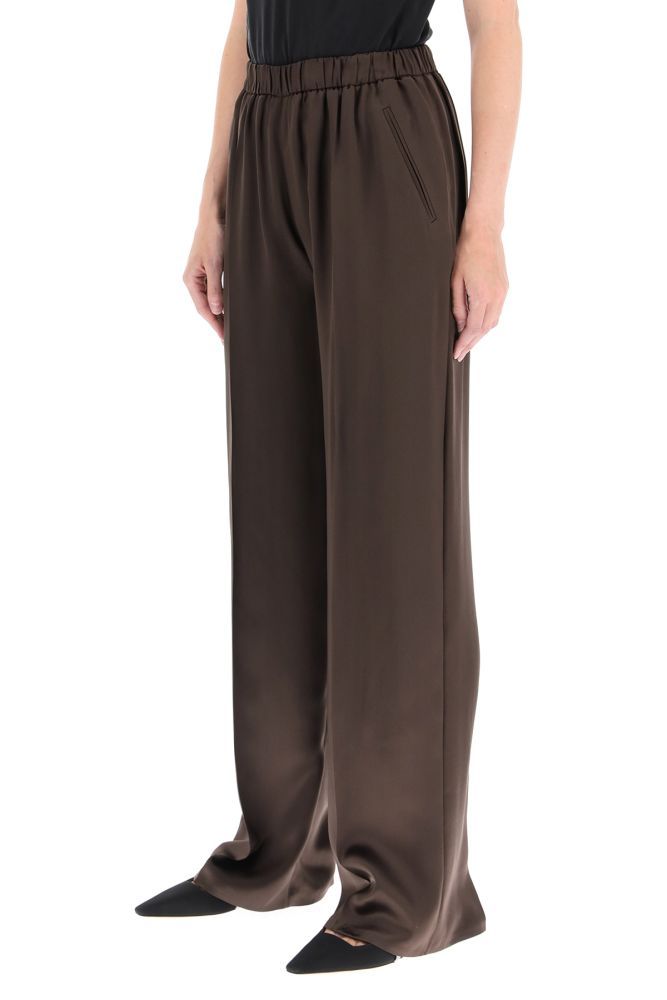 Magda Butrym flowing silk blend satin trousers with a comfortable fit, loose leg and well-defined ironed crease. High elasticated waist, side welt pockets. The model is 177 cm tall and wears a size FR 34.