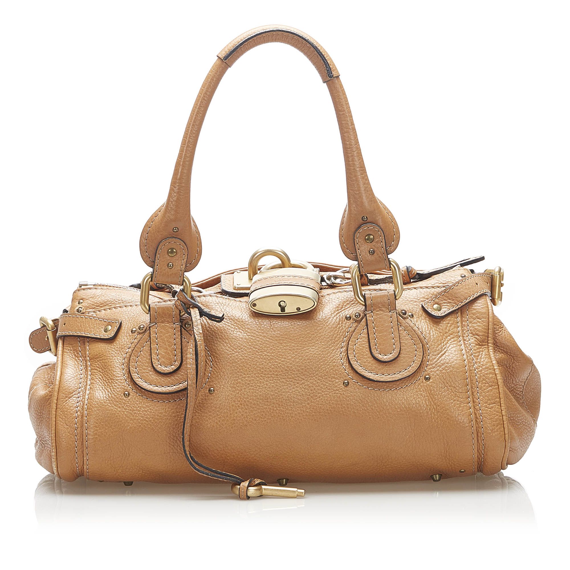 VINTAGE. RRP AS NEW. The Paddington handbag features a leather body, a rolled leather handles, a gold-tone padlock detail, a top zip closure, and an interior zip pocket.Exterior back is discolored. Exterior bottom is discolored. Exterior corners is discolored. Exterior front is discolored. Exterior handle is discolored. Exterior side is discolored. Buckle is tarnished. Studs is tarnished.

Dimensions:
Length 16cm
Width 35cm
Depth 18cm
Hand Drop 18cm
Shoulder Drop 18cm

Original Accessories: Key

Color: Brown
Material: Leather x Calf
Country of Origin: France
Boutique Reference: SSU94358K1342


Product Rating: GoodCondition