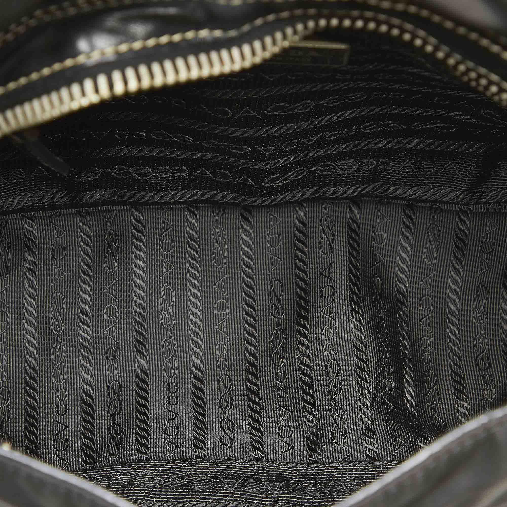 VINTAGE. RRP AS NEW. This shoulder bag features a nylon body with leather trim, tassel detail, a flat leather strap, a front flap with magnetic closure, and an interior zip pocket.Exterior back is discolored. Exterior bottom is discolored. Exterior corners is discolored. Exterior front is discolored. Exterior handle is discolored. Exterior side is discolored. Buckle is scratched and tarnished. Lock is scratched and tarnished. Studs is scratched and tarnished. Zipper is scratched and tarnished. Interior lining is discolored. Interior pocket is discolored.

Dimensions:
Length 17cm
Width 30cm
Depth 9cm
Shoulder Drop 25cm

Original Accessories: Charm

Color: Black
Material: Fabric x Nylon x Leather x Calf
Country of Origin: Italy
Boutique Reference: SSU94297K1342


Product Rating: GoodCondition
