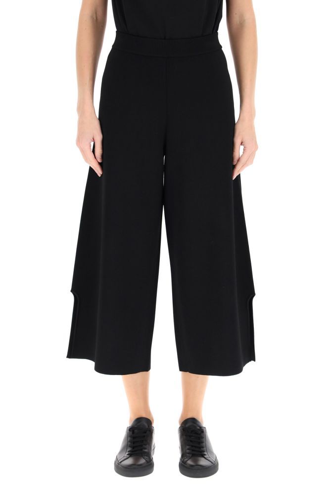 Stella McCartney cropped trousers made from a sustainable viscose blend knit, with a wide leg cut and a high elasticated waist. The minimal line is decorated with an asymmetrical detail at the hem.La modella è alta 177 cm e indossa la taglia IT 38.