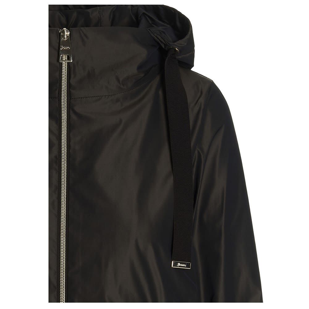 Tech fabric jacket featuring a removable hood with a drawstring, an asymmetric hem, long sleeves and a full zip closure.