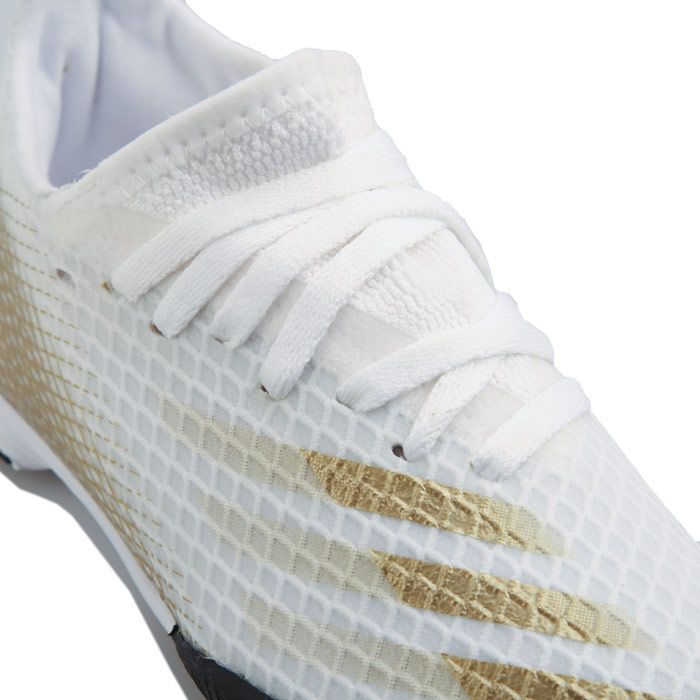 Childrens adidas X Ghosted.3 Turf Football Boots in white gold.- Water-resistant mesh upper.- Lace fastening.- Regular fit.- Football boots for artificial turf.- Stretchy tongue. - EVA midsole.- adidas branding.- Rubber sole.- Textile and synthetic lining  Synthetic sole.- Ref.: EG8214