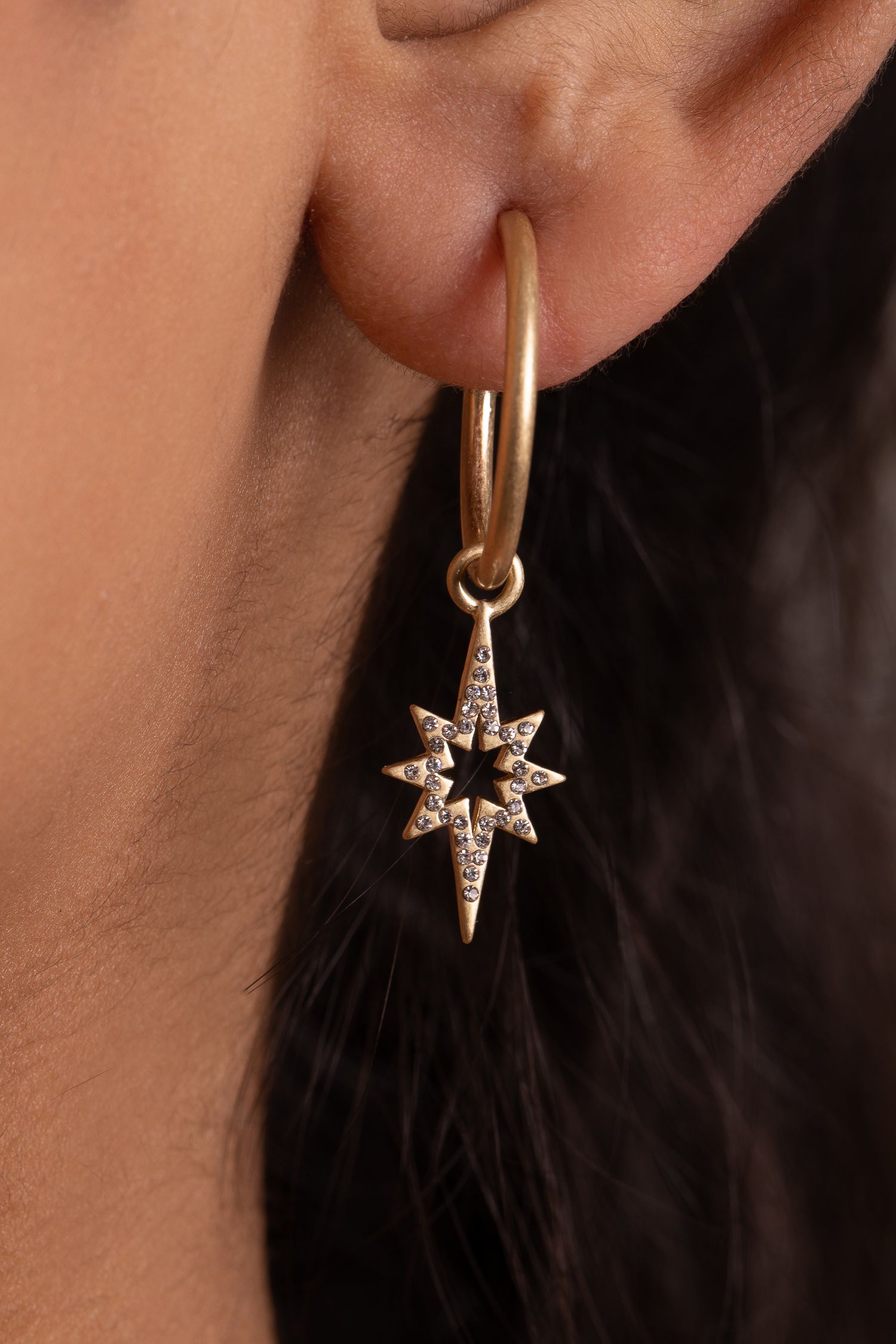 Our new Kate Thornton gold plated 'Celeste' star drop earrings will really make a style statement this season. A striking piece of jewellery which makes the perfect accompaniment to any outfit.  Delicate, eye catching and with a contemporary edge these drop earrings will look great when worn alone or paired with other styles for a really on trend look. The gold tone earrings feature an 18mm hoop and delicate 27mm pave star charm. Presented in a KTx jewellery pouch to keep your jewellery safe or ideal for gifting!