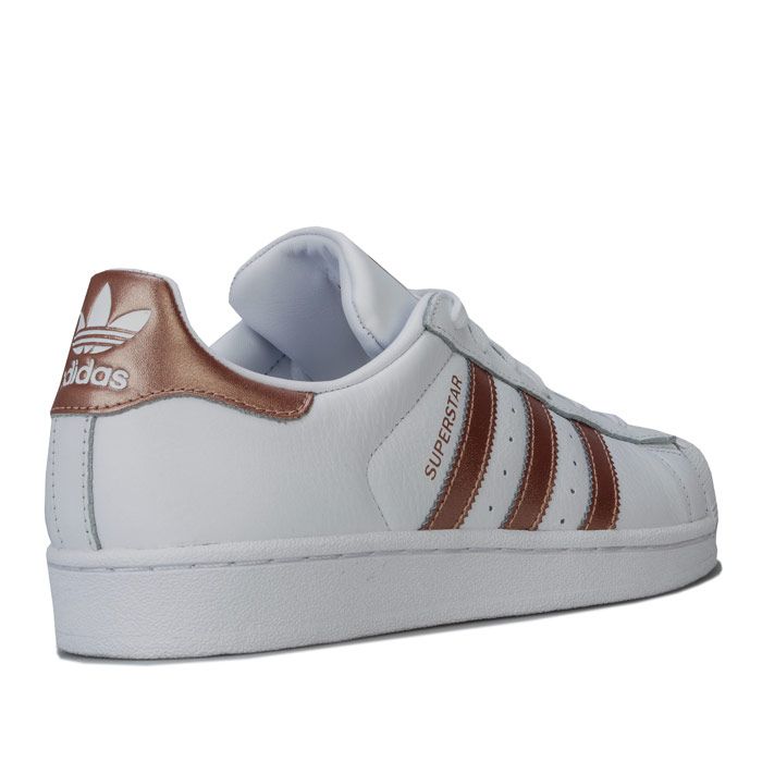  adidas Originals Superstar Trainers in footwear White - copper metallic. – Premium leather upper. – Lace closure. – Classic rubber shell toe. – Padded collar and tongue. – Synthetic leather lining to heel. – Comfortable textile lining. – Metallic 3-Stripes to sides with printed ‘Superstar’ to side. – Trefoil branding printed at tongue. – Metallic heel patch with debossed Trefoil logo. – Removable cushioned sockliner. – Herringbone-pattern rubber cupsole. – Leather and synthetic upper – Textile and synthetic lining – Synthetic sole. – Ref: EE7399