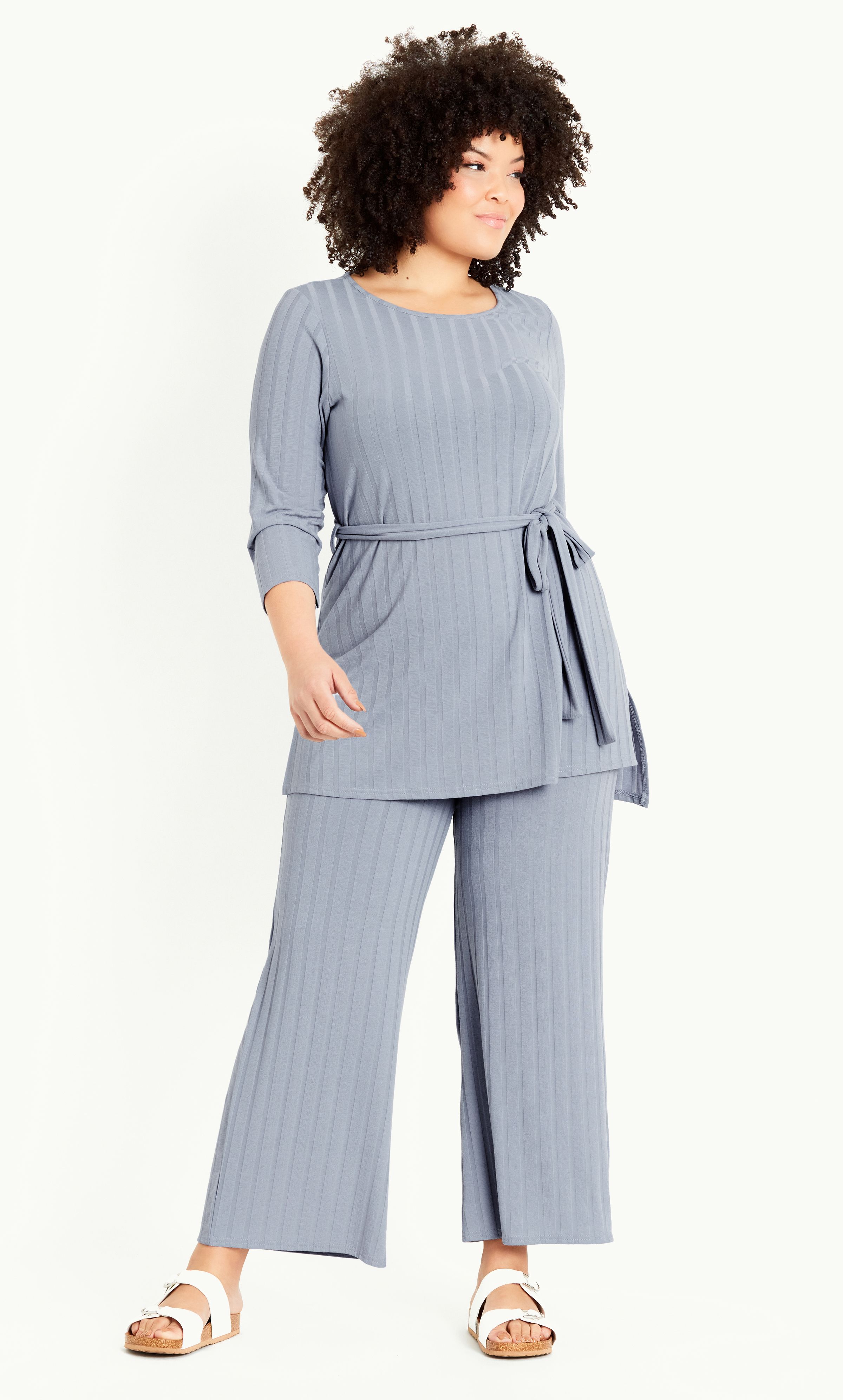 Add to your loungewear rotation with the cosy stylings of our ultra soft Ribbed Belted Tunic! Offering a crew neckline, long sleeves and removable self-tie waist belt, this top seamlessly fuses everyday comfort with fashion-forward style. Key Features Include: - Crew neckline - Long sleeves - Removable self-tie waist belt - Unlined - Relaxed fit - Soft stretch rib knit fabrication - Pull over style - Below hip length - Side splits to hem Team with leggings and slides for practical home style.
