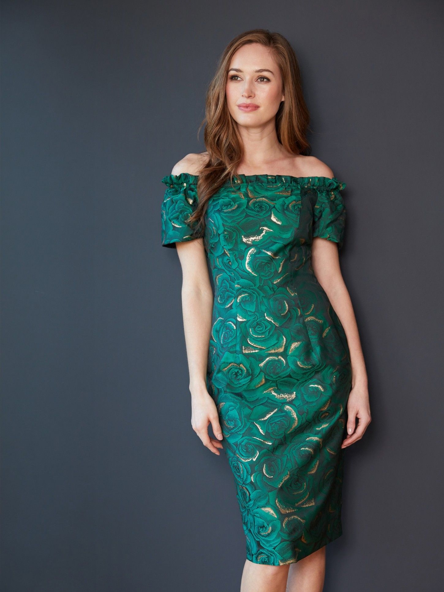 This glamorous stretch floral jacquard dress by Gina Bacconi will make you feel stunning. The off the shoulder neckline with ruffle detailing adds an elegant finish. It is fully lined and is fastened with a contrast zip at the back of the dress. Perfect for a party or a special occasion.
