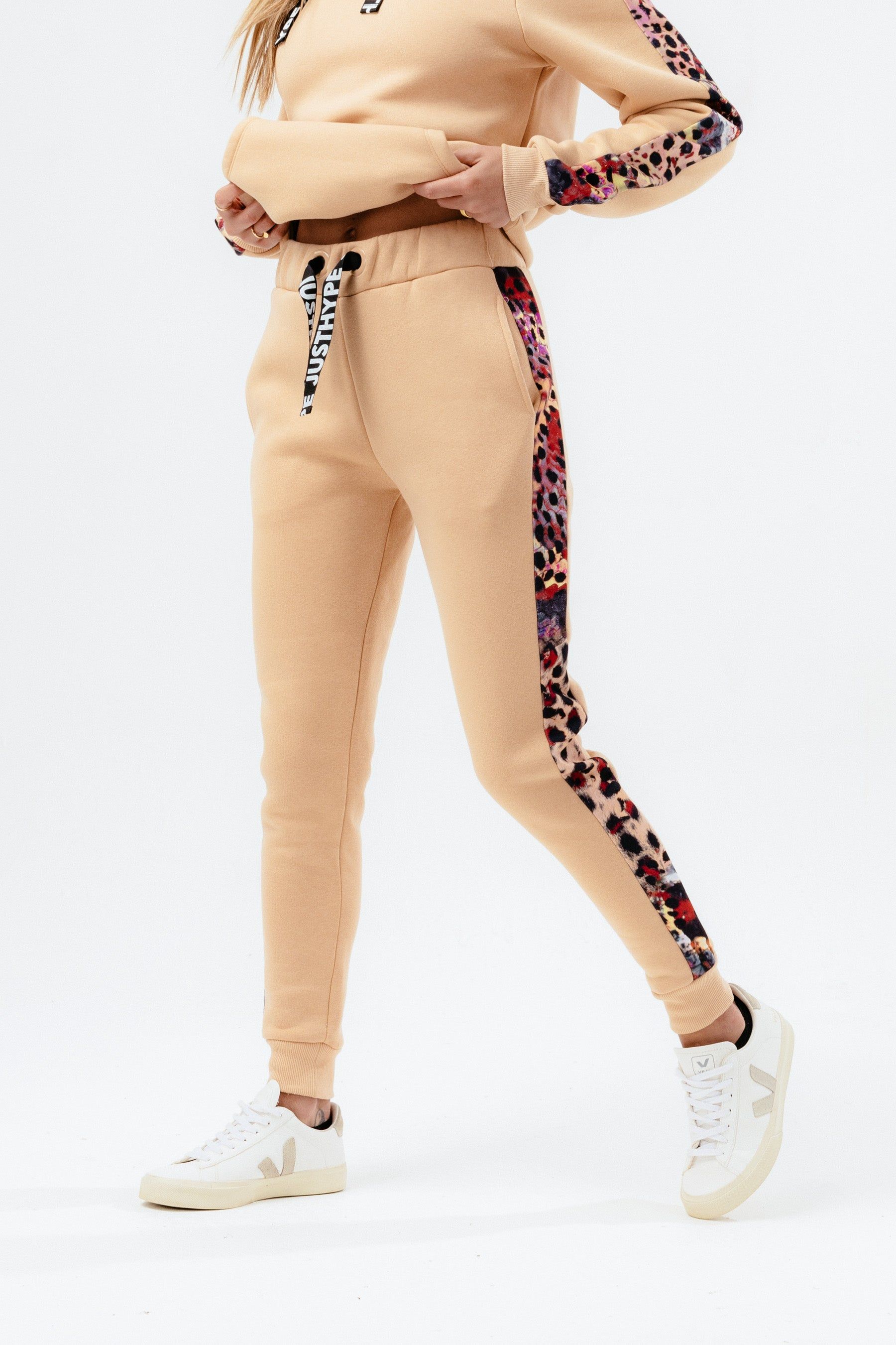 Meet the HYPE. Women’s Hazelnut Animal Print Label Joggers. Made from an 80% cotton 20% poly fabric blend in hazelnut for ultimate comfort. Featuring screen printed drawstrings and sublimated animal print panels, these joggers are the perfect addition to your jogger 'drobe. Wear with the matching HYPE. Hazelnut Animal Print Label Hoodie and T-Shirt for a comfortable, off-duty look.