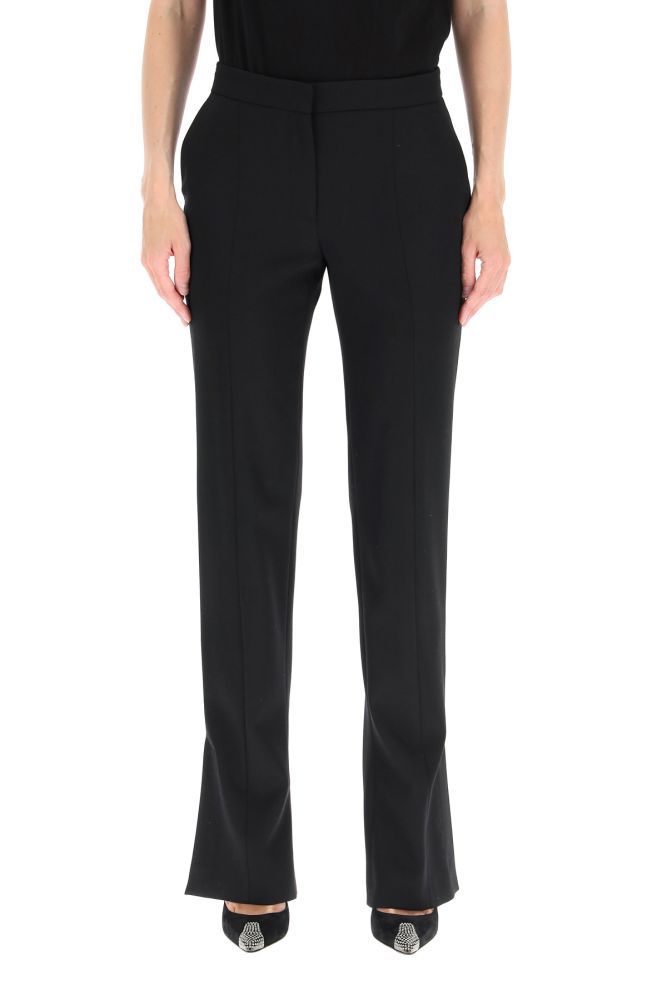 Alexander McQueen tailored cigarette trousers in lightweight wool fabric with slashed ankle details. Straight tapered leg, side French pockets, a rear welt pocket, front concealed zip and hook closure. The model is 177 cm tall and wears a size IT 40.