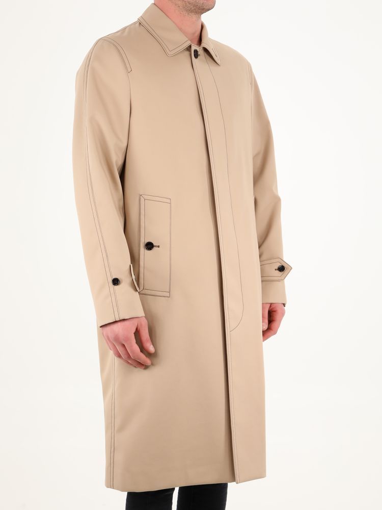 Alderford single-breasted coat in beige cotton with contrasting stitching. It features front closure, classic collar, two side pockets with button, buttoned cuffs, back slit and inner lining with tartan motif. The model is 184cm tall and wears size 48.  