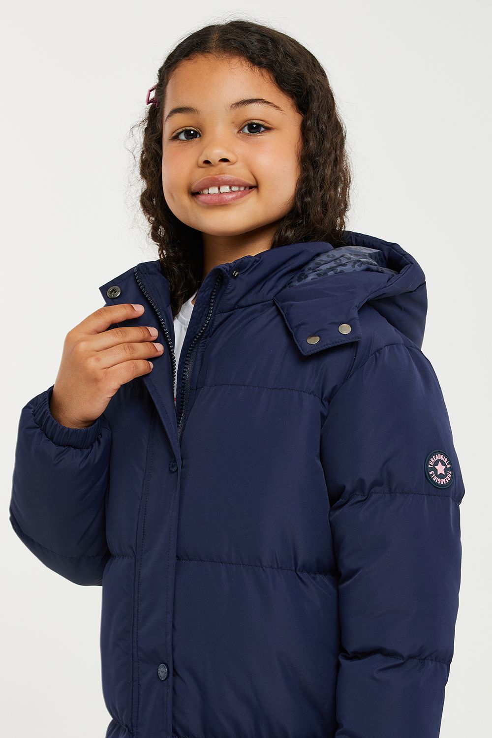 This longline hooded, padded jacket from Threadgirls features a two-way zip and popper fastenings. The jacket also has two side pockets, elasticated cuffs, and branded badge on the sleeve. Perfect for keeping warm this back-to-school season, other colours and styles are also available.