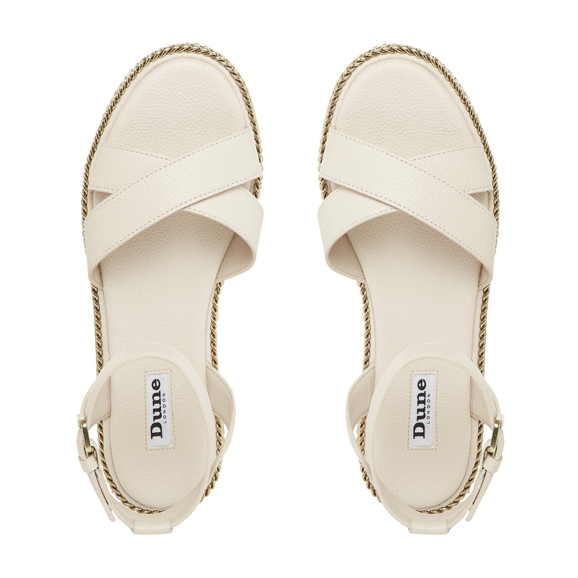 Toughen up summer and holiday edits with this sandal. Fitted with a buckled ankle strap and crossed bands at the upper. Its comfortable chunky sole is embellished with striking chains.