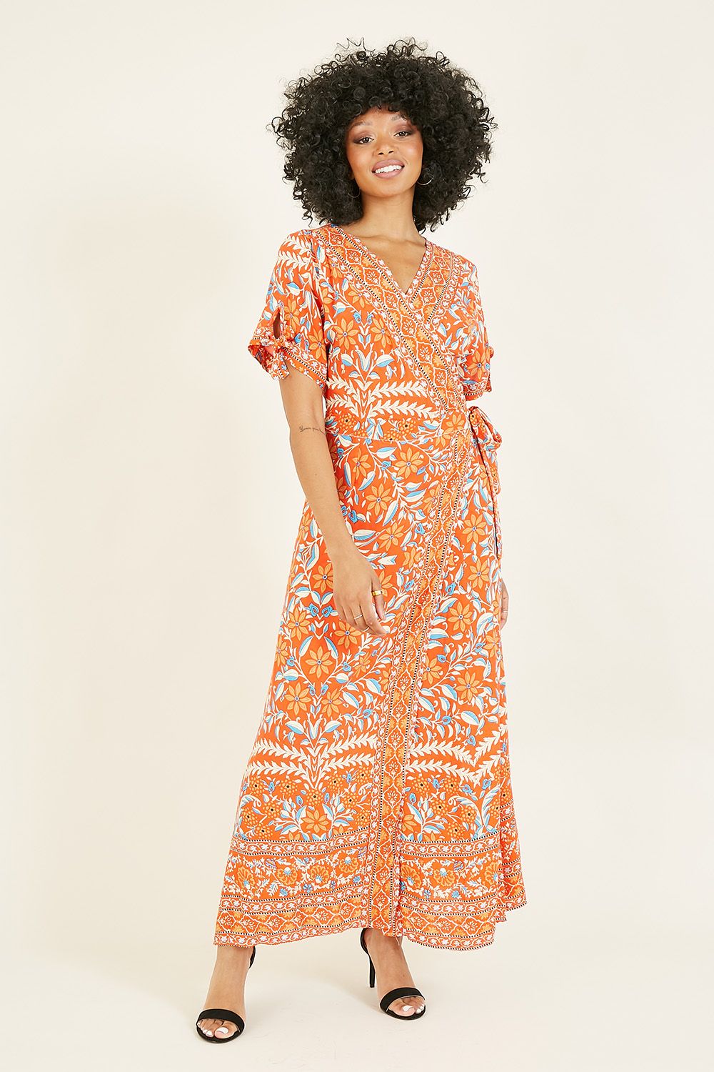 Sunny days call for bright and bold prints and this yumi orange floral printed dress certainly delivers. With a wrap style v neck, this dress pulls you in at the waist and features button up sleeves.  crafted with the sun in mind, stay cool is this lightweight, breathable fit.
