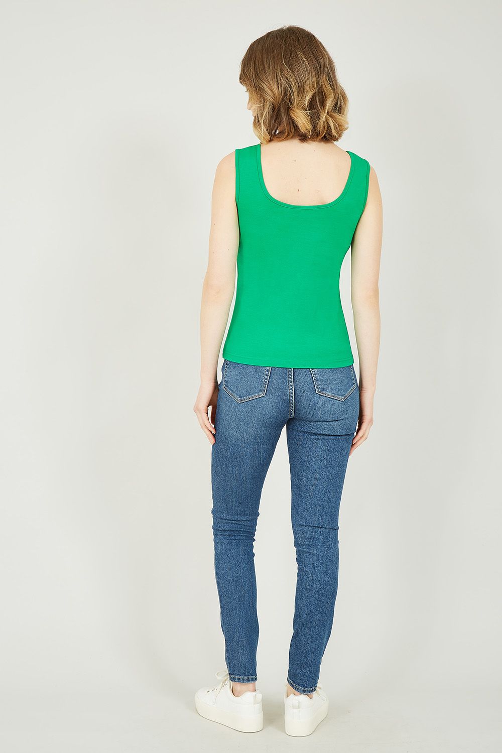 Sommigen noemen het een basic, wij noemen het must-have. Het Yumi groene hemdtopje is dit jaar het meest versleten kledingstuk in je garderobe. Het topje van 100% katoen is ademend, voelt zacht aan en is enorm veelzijdig. Hij heeft een klassieke pasvorm, ronde halslijn en is bijgesneden op de heupen. Combineer dit topje met je favoriete spijkerbroek of denim rok en sneakers voor een nonchalante look. Onze favoriete manier om het te dragen is met jeans en een lange kimono voor die koele lentemiddagen.