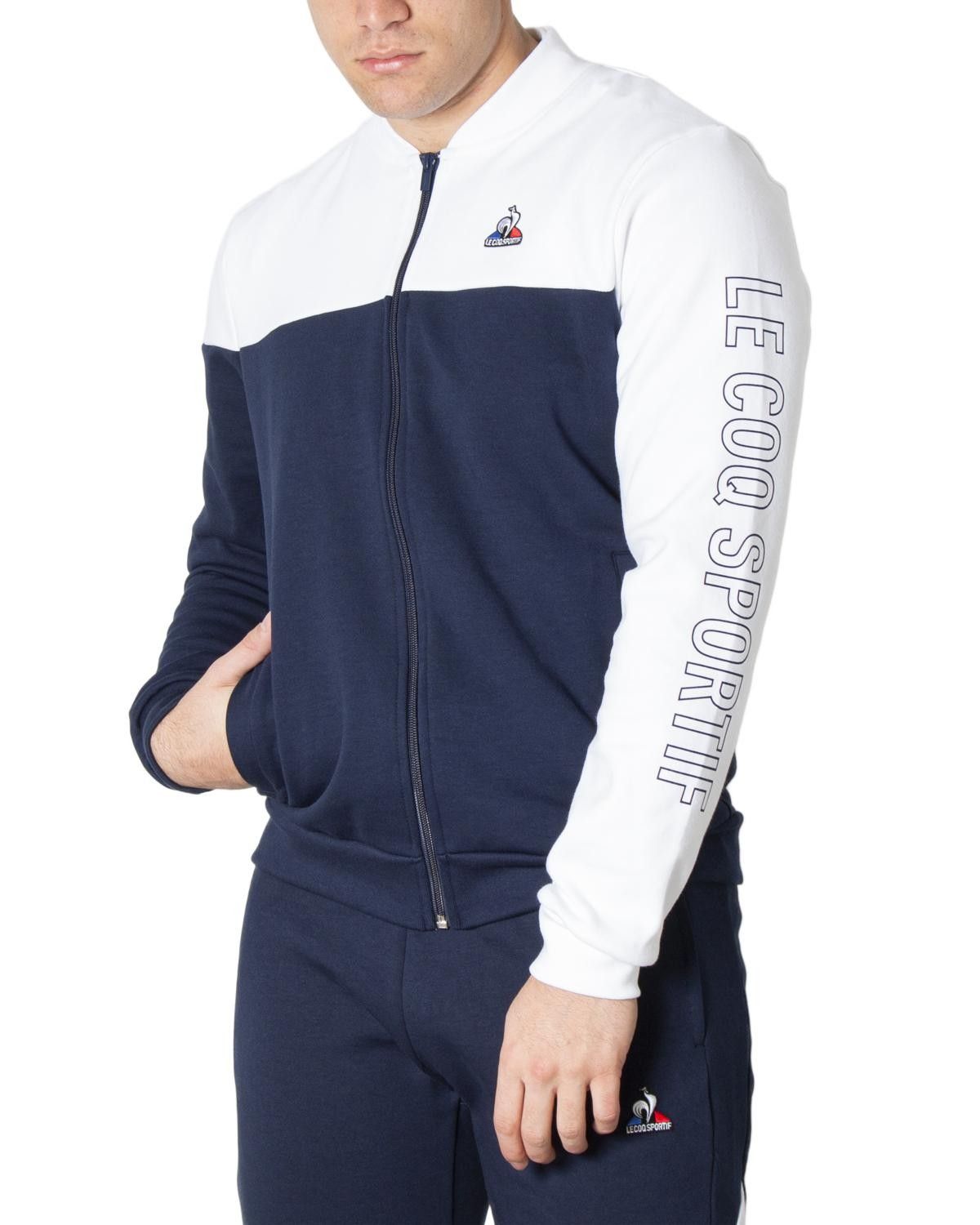 Brand: Le Coq Sportif Gender: Men Type: Sweatshirts Season: Spring/Summer  PRODUCT DETAIL • Color: blue • Pattern: print • Fastening: with zip • Sleeves: long • Neckline: turtleneck • Pockets: front pockets  COMPOSITION AND MATERIAL • Composition: -85% cotton -15% polyester  •  Washing: machine wash at 30° -85% Cotton -15% Polyester