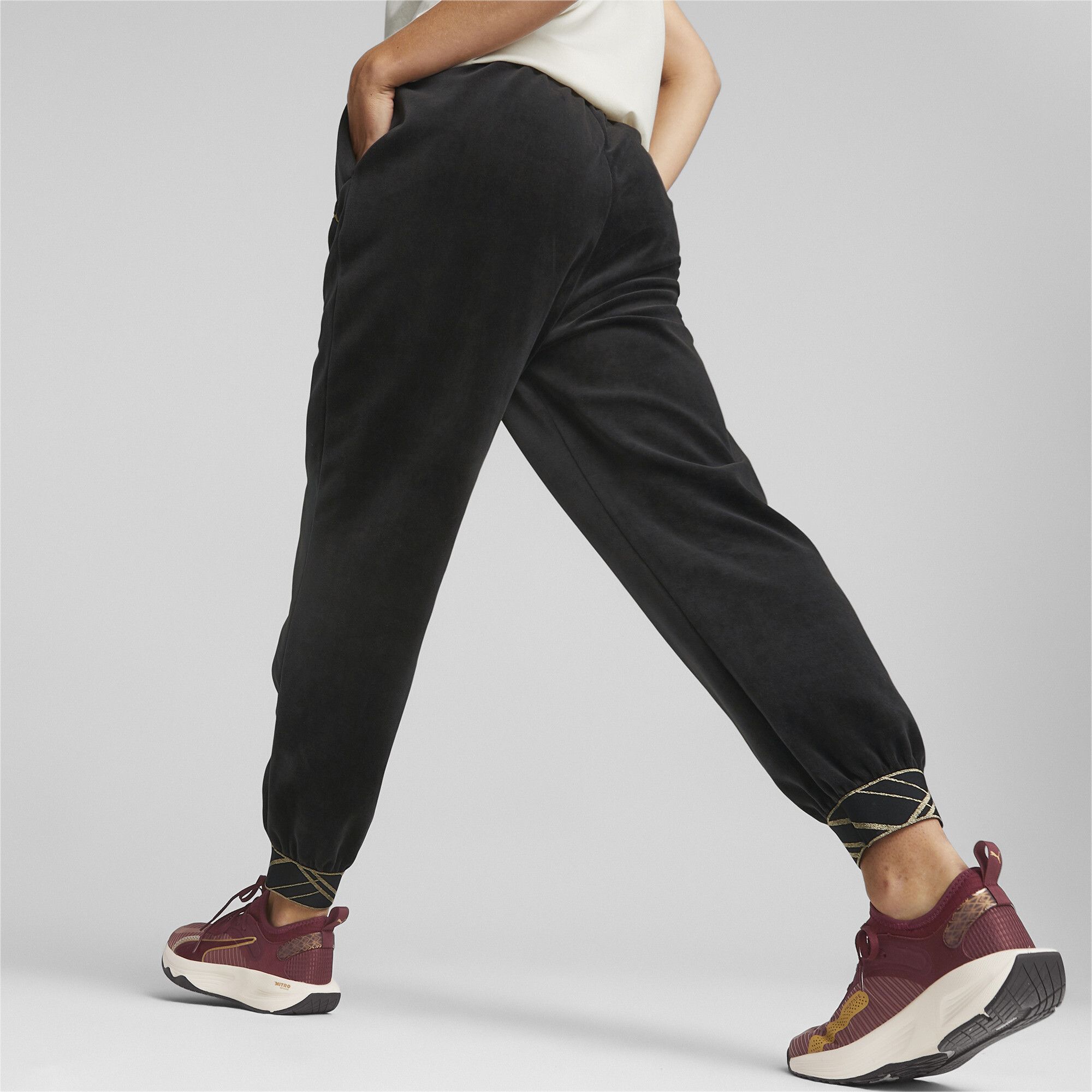 PRODUCT STORY Serve Y2K realness out on the track in the Deco Glam Velour Training Pants. The playful metallic trims inject a bit of sparkle into any training session, while our dryCELL technology is ready to wick away sweat as you get down to business. Hit your personal best in style. FEATURES & BENEFITS : dryCELL: Performance technology designed to wick moisture from the body and keep you free of sweat during exercise DETAILS : Regular fit Elastic waist and cuffs with metallic details Two side seam pockets PUMA Cat Logo on left thigh