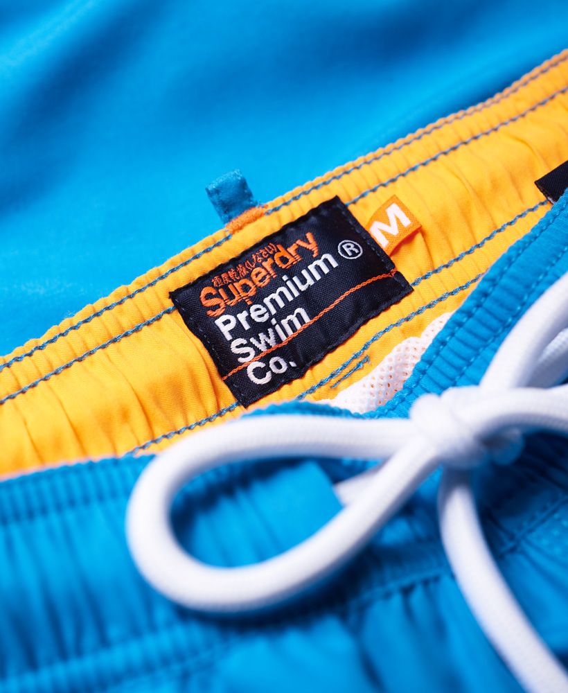 Superdry men’s Waterpolo swim shorts. A pair of swim shorts featuring an applique print on one leg and a two colour embroidered Superdry logo above the leg opening. The swim shorts come with two front pockets and one zip pocket on the back. The Waterpolo swim shorts also have an elasticated waistband with a drawstring fastening, signature orange stitching accents and are finished with an inner mesh lining for added comfort.