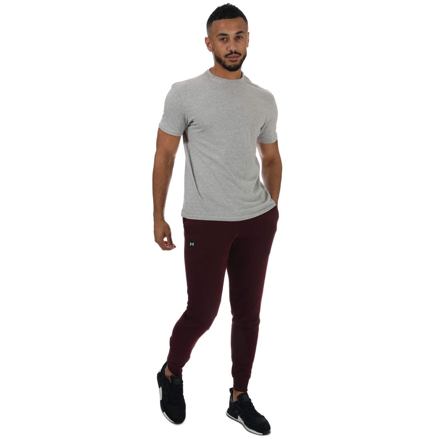 Mens Under Armour Rival Fleece Joggers in burgundy.- Encased elastic waistband with external drawcord.- Open hand pockets & secure.- Snap back pocket.- Ribbed cuffs.- Ultra-soft  mid-weight cotton-blend fleece with brushed interior for extra warmth.- Tapered leg fit- Main Material: 80% Cotton  20% Polyester. Machine washable.- Ref: 1357128600
