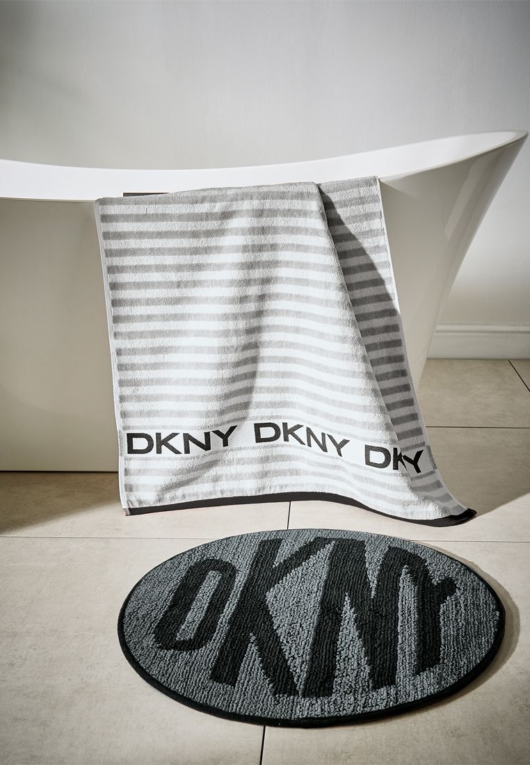 Get your day off to a great start by jumping out of the shower and onto one of these reversible DKNY bath mats. Made from tufted cotton and featuring the iconic DKNY logo, reflecting the spirit and energy of New York.