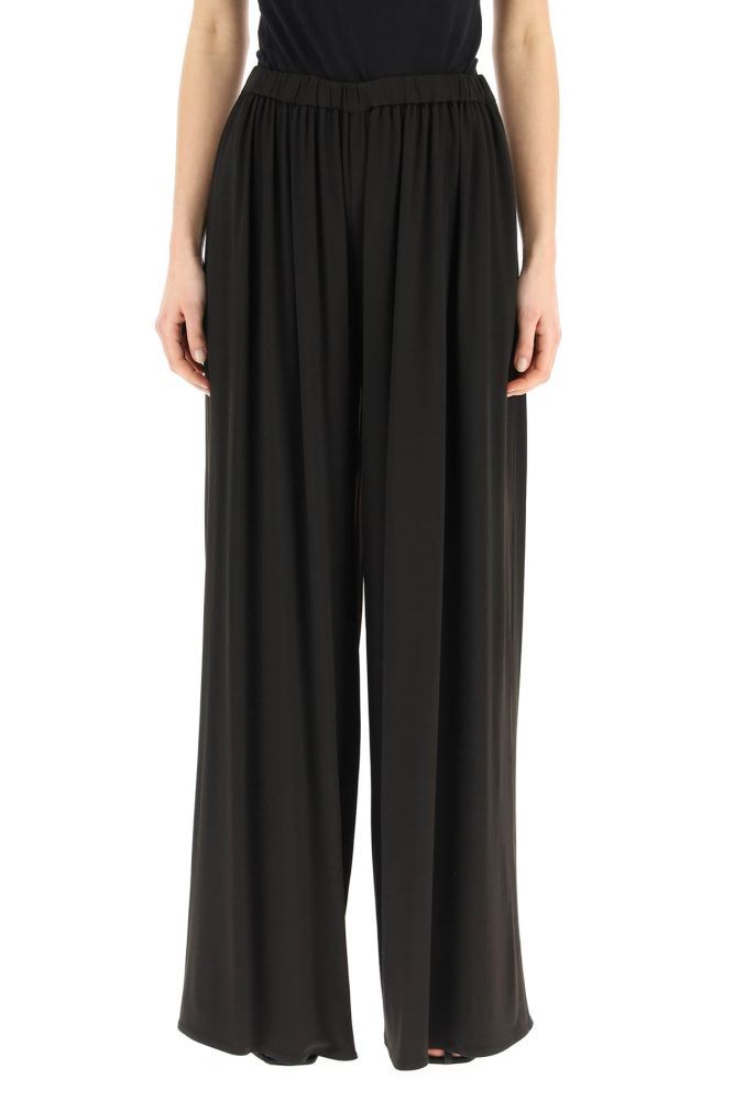 Palazzo pants in stretch viscose by Magda Butrym, featuring elasticated waist and side inseam pockets. The model is 177 cm tall and wears a size FR 36.