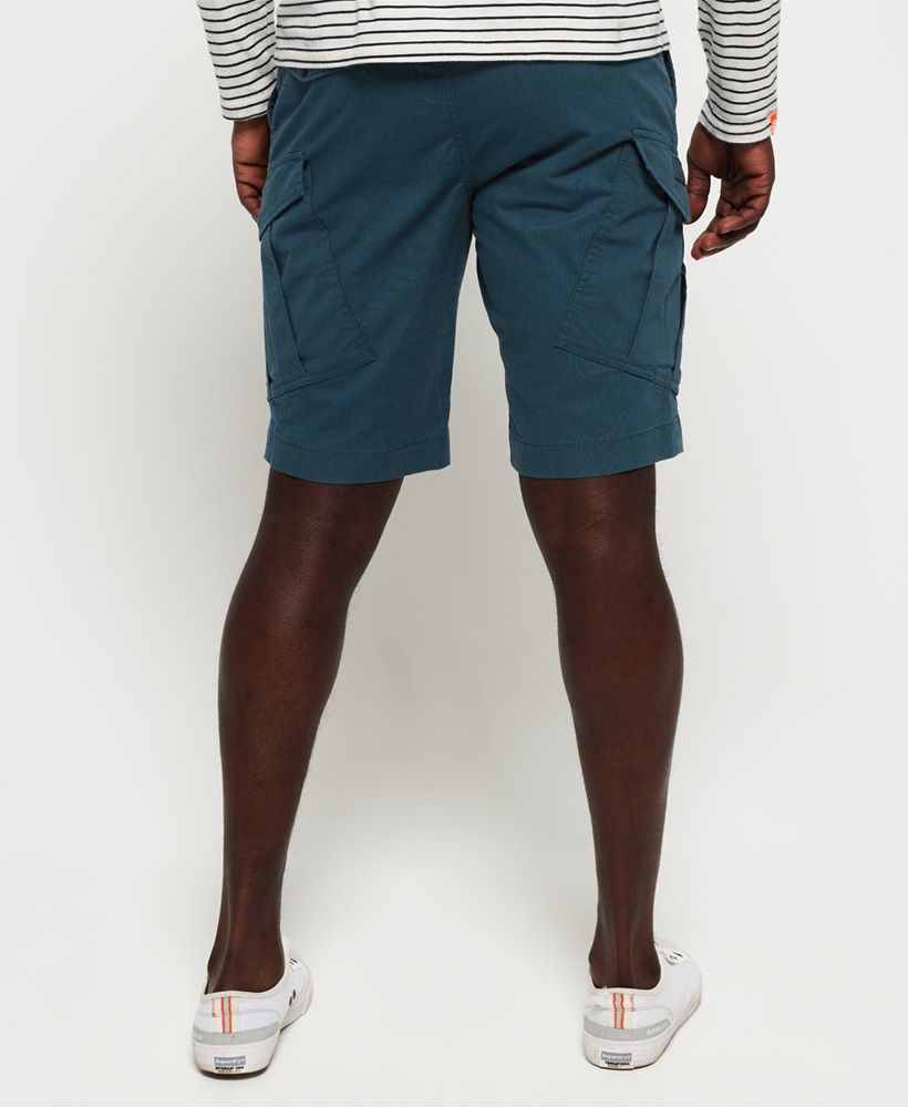 Superdry men's World Wide cargo shorts. Update your wardrobe collection of smart/casual shorts with a pair of World Wide cargo shorts. Made from a soft chino twill fabric, these shorts have an elasticated waist with drawcord fastening, two front pockets and two back and leg pockets with snap fastenings. The World Wide cargo shorts are finished with a silicone-style logo badge on the right leg pocket and a subtle logo patch above the back pocket. Style up with a crisp short-sleeve shirt or go casual with your favourite Superdry t-shirt or polo.