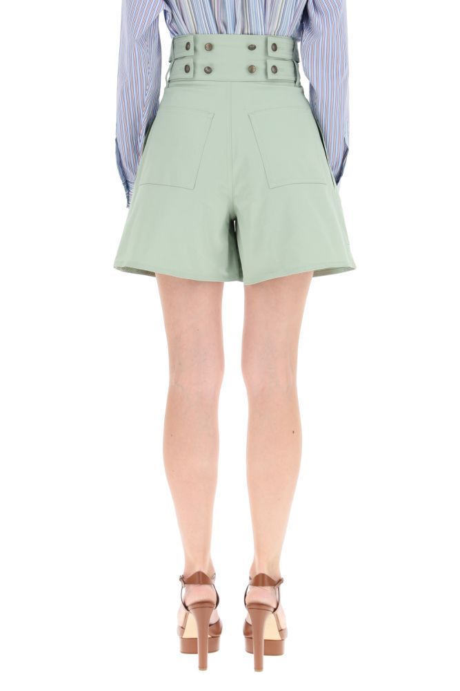 ETRO shorts in stretch cotton gabardine with a high-waisted design and front pleats, embellished with shield buttons on the front closure and on the back. It features side slit pockets and back patch pockets. The model is 177 cm tall and wears a size IT 38.