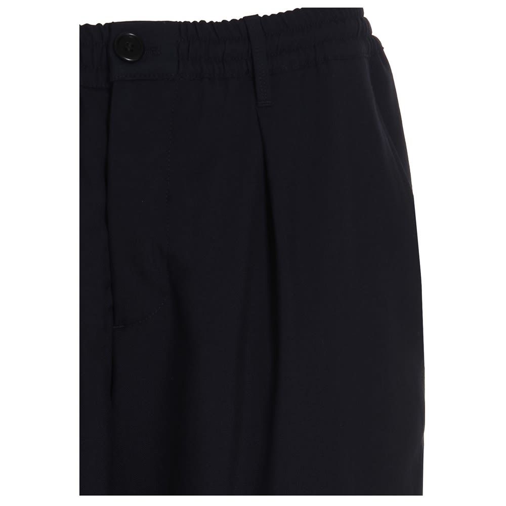 Virgin wool trousers with an elastic waistband, a button closure and a loose leg.