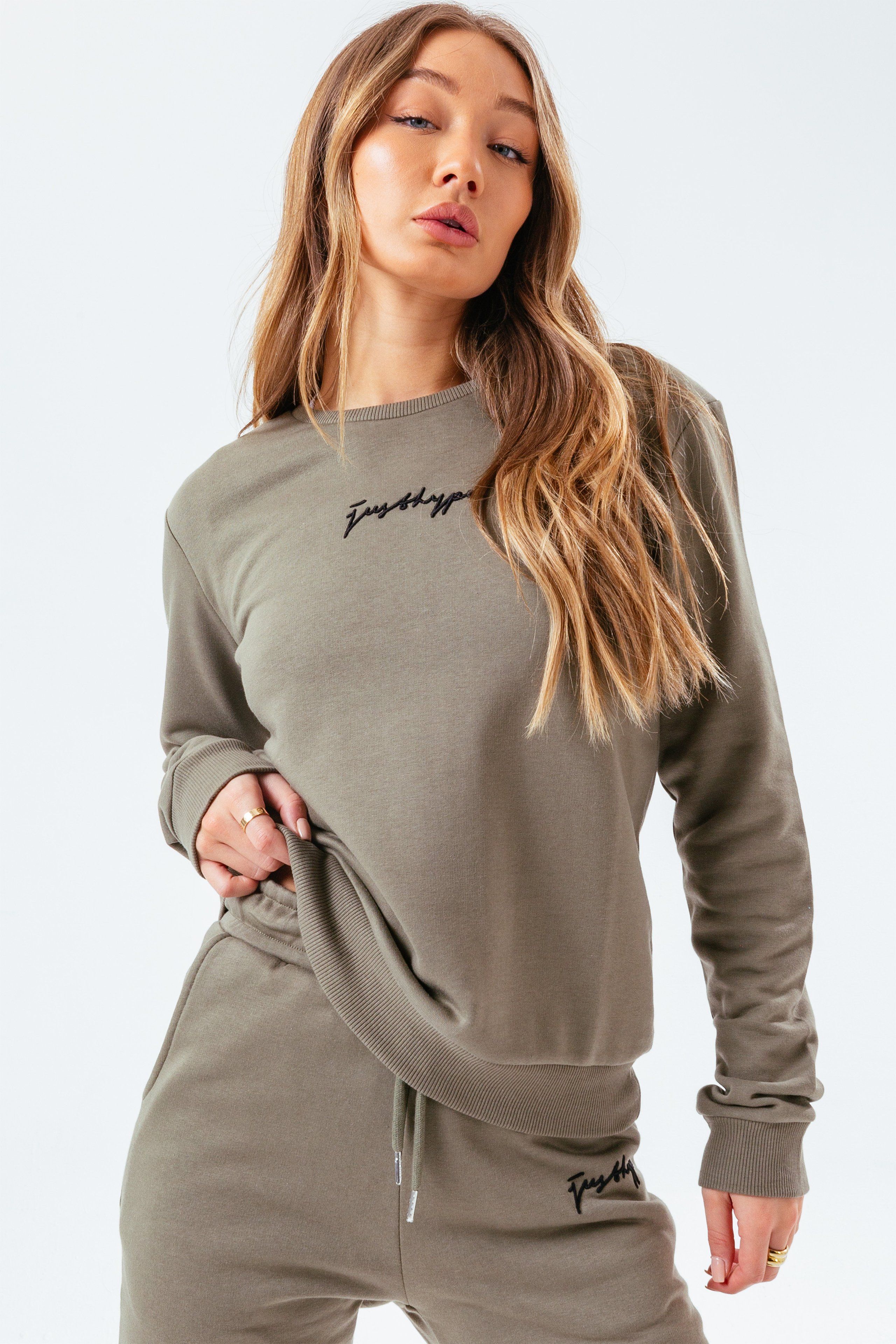 The perfect jumper to add to your everyday rotation. The HYPE. Women's Moss Signature Crewneck is perfectly versatile for every occasion, whether your dressing up or dressing down. Designed in a moss green 80% cotton and 20% polyester fabric base, finished with a contrasting white just hype scribble logo for supreme amount of comfort and style. With a crew neckline and long sleeves for a classic fit. This essential jumper can be work tucked into a pair of high-waisted denim wash jeans for a smart casual look, or with a pair of leggings for your morning workout. Machine wash at 30 degrees.