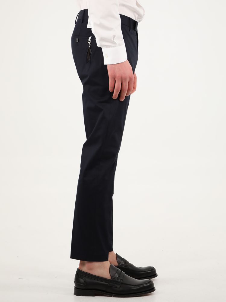 Blue cotton gabardine trousers with straight fit. They feature two side welt pockets, two rear pockets with button, rear charm and belt loops. The model is 184cm tall and wears size 48.