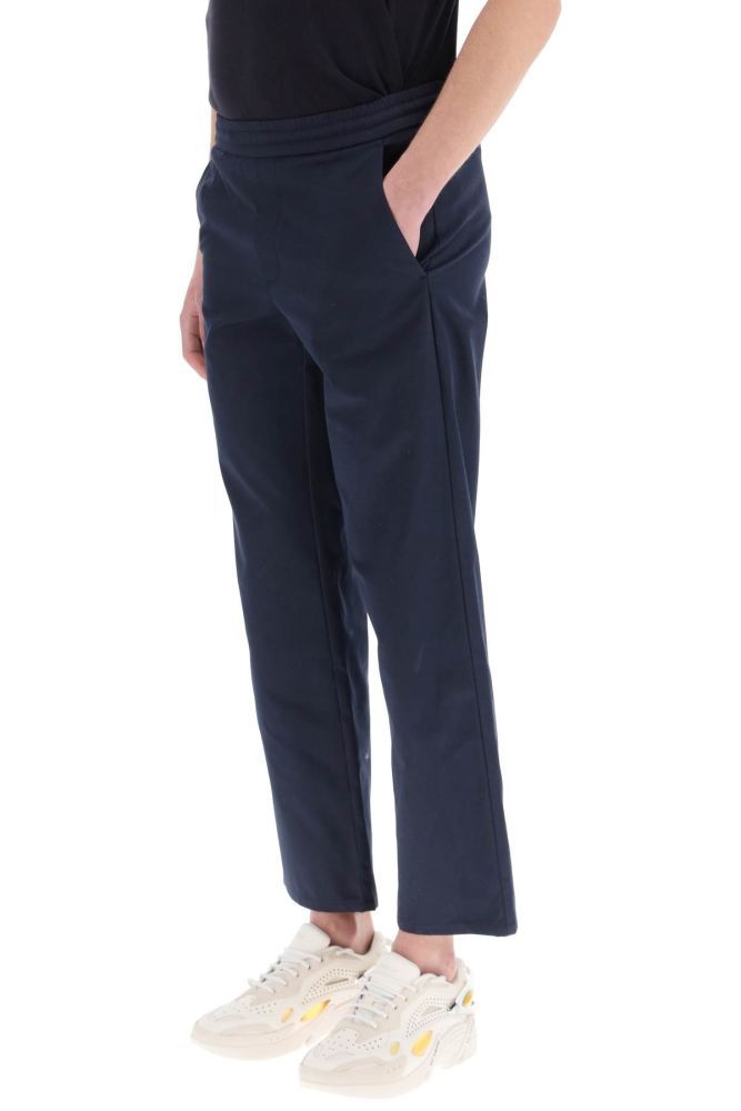 MSGM semi-formal trousers made of resined cotton with a straight and loose leg cut with ankle length. Elasticated waist with internal drawstring, side slanted pockets, one back patch pocket with logo label detail. Regular fit. The model is 187 cm tall and wears a size IT 48.