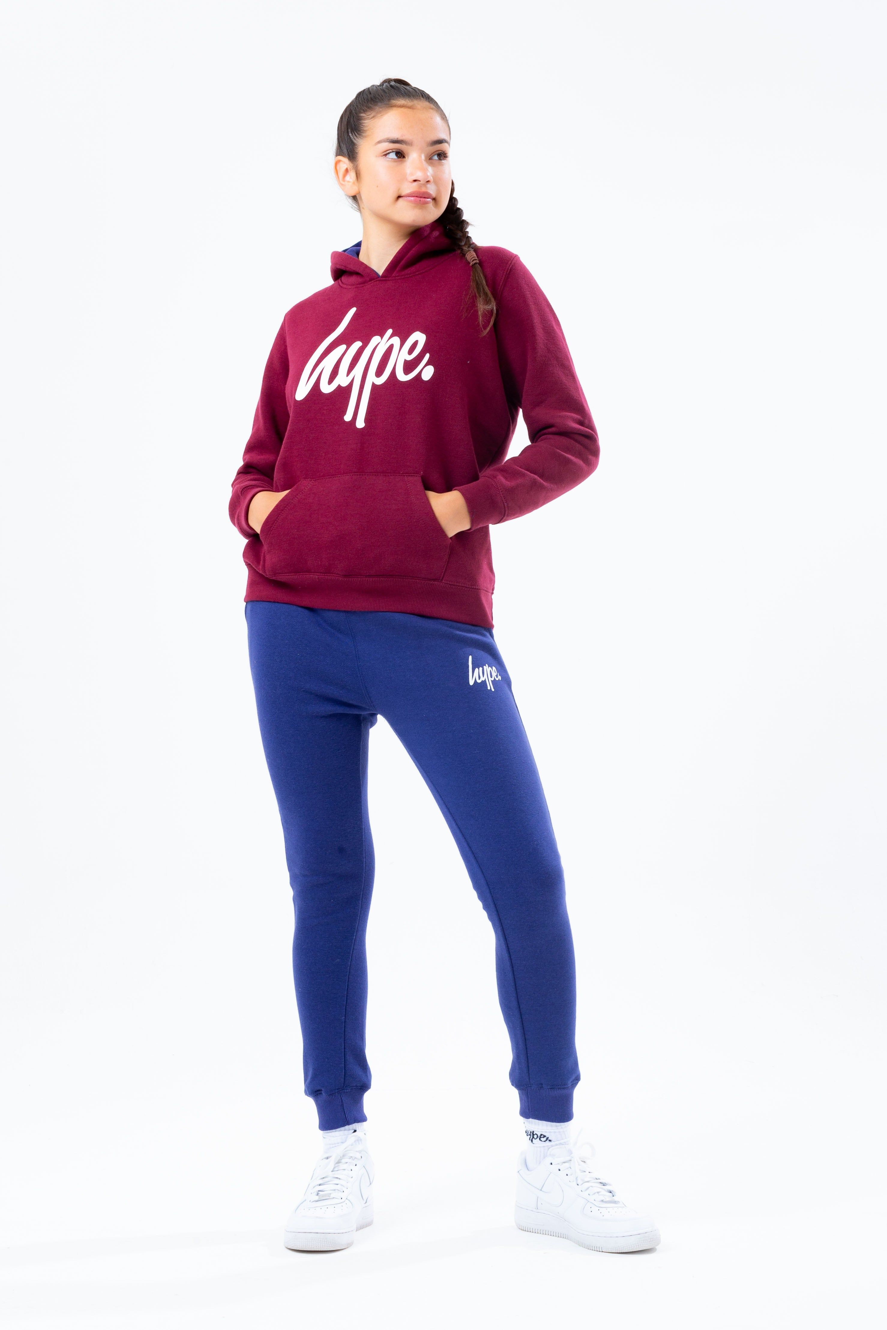 The HYPE. burgundy hoodie navy jogger kids set is perfect for off-duty casual days. Designed in a burgundy and navy fabric base with the ultimate soft-touch sweat fabric for supreme comfort. The kids hoodie highlights a fixed hood, fitted hem and cuffs, finished with the iconic HYPE. script logo  across the front. The joggers boast an elasticated waistband and fitted cuffs with the HYPE. mini script logo. Wear stand alone or as a set with a pair of box fresh kicks to complete the look. Machine wash at 30 degrees.