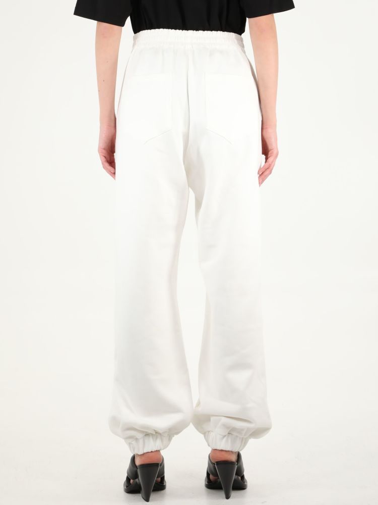 White joggers with The Attico embossed logo on the front, elasticated waist and ankles. The model is 180cm tall and wears size 38.  