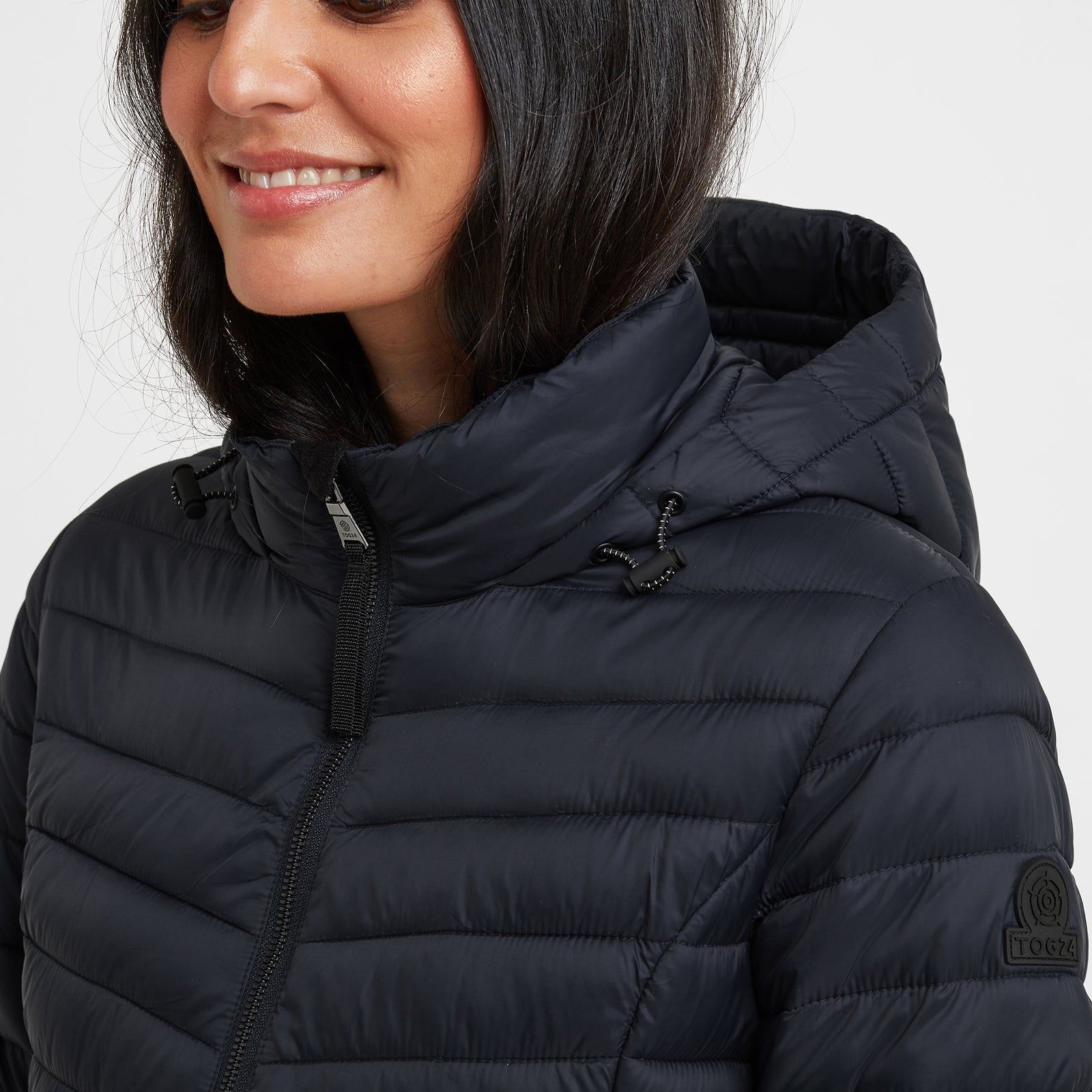Lightweight, wind resistant and buttery soft, our Garriston quilted jacket gives you warmth without adding bulk and is designed in bold, chevron colour blocks inspired by moorland heather and the churning Atlantic sea. This distinctive and versatile jacket is perfect for travel as it squishes down small and springs back into shape when you need it. The thermal filling is made from recycled plastic bottles, so you'll be doing your bit to protect the environment too. Garriston has a cosy inner collar for added comfort and a fixed, insulated hood with toggle adjusters. There are two handy zip up pockets and a full length, easy pull zip at the front. The finishing touch is our iconic embossed rubber Yorkshire Rose badge on the sleeve.
