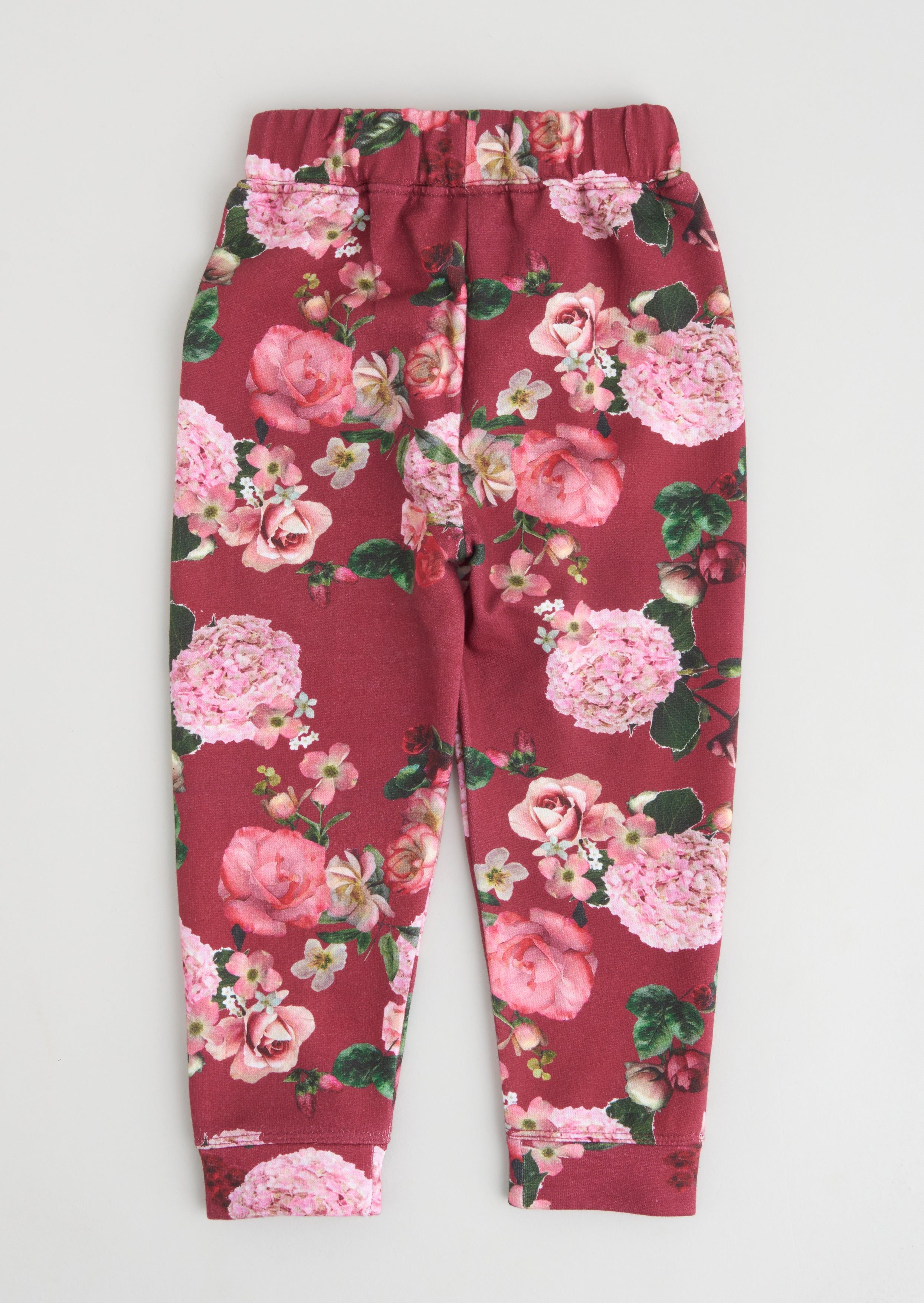 Opt for fun florals with these super cute joggers. Beautiful blooms printed on a super soft loopback with a satin bow and elasticated waist. Wear with the matching sweat and trainers for a cute co-ord. > Angel & Rocket cares – made with fairtrade cotton > Colour: Ruby red > About me: 80% cotton 20% polyester  > Look after me – Think planet > Wash at 30c