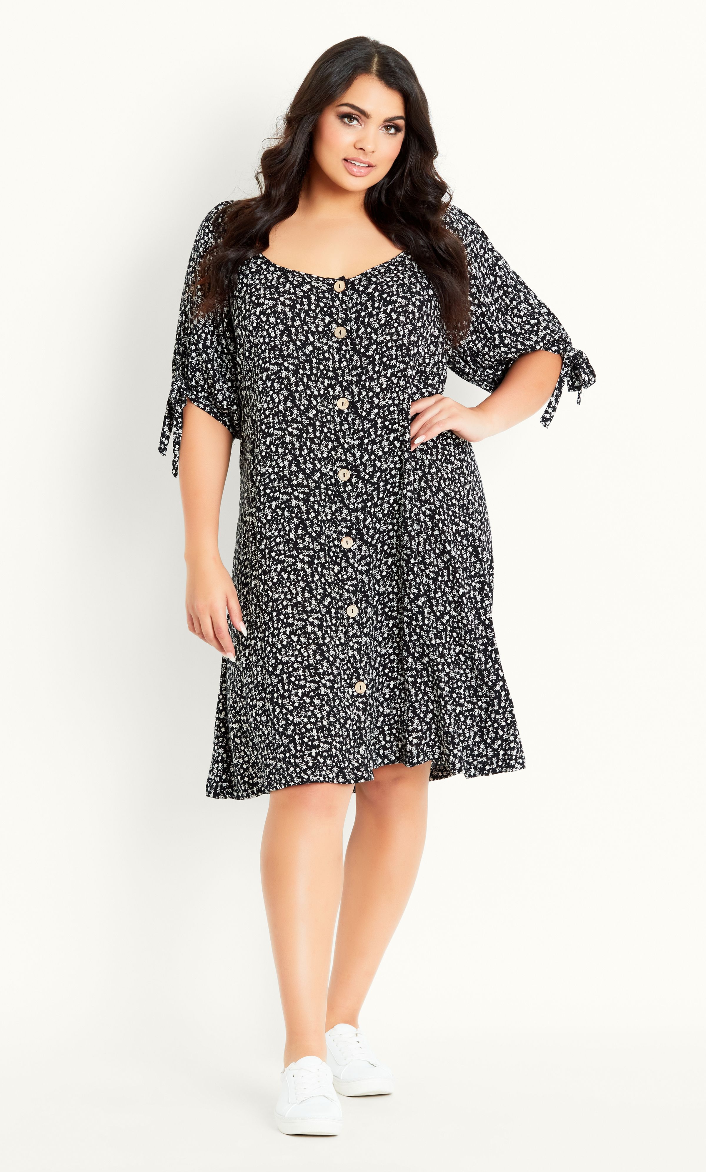 Whether you're off on a shopping spree or taking a beachside stroll, the Ditsy Tie Sleeve Dress has you covered! Offering a sweet buttoned front, wide scoop neckline and knee length hem, this day dress ticks all the boxes. Key Features Include: - Wide scoop neckline - Elbow-length sleeves with tie feature - Buttoned front - Unlined - Relaxed fit - Knee length Finish with white trainers and your favourite tote.