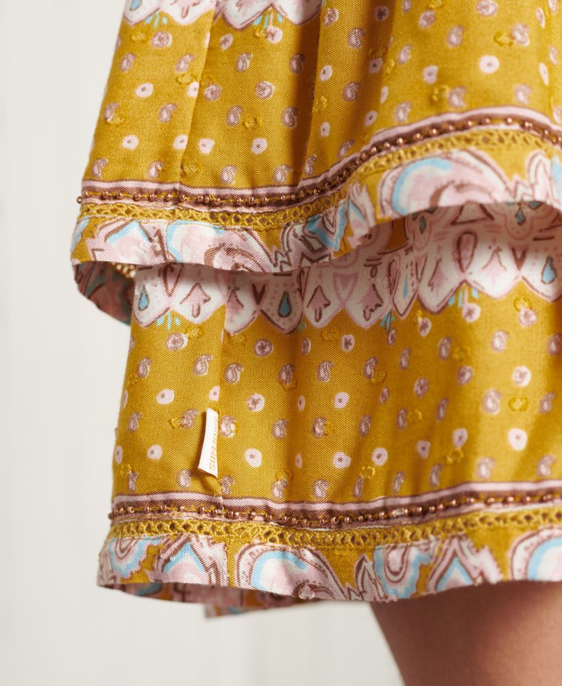 Get the ultimate boho vibe with the vintage inspired Ameera Mini Smocked Skirt, featuring a smocked waistband, and beaded hems.Smocked waistLace detailingBeaded hemsSignature logo tabSignature logo metal badge