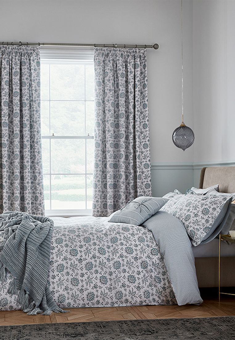This lively stylised floral design oozes freshness in calming celadon and grey on a soft white base.  The small-scale geo reverse with tiny dot detail adds interest. The main bed design also graces the matching curtains to further enhance the Cherine collection. Made in Pakistan.