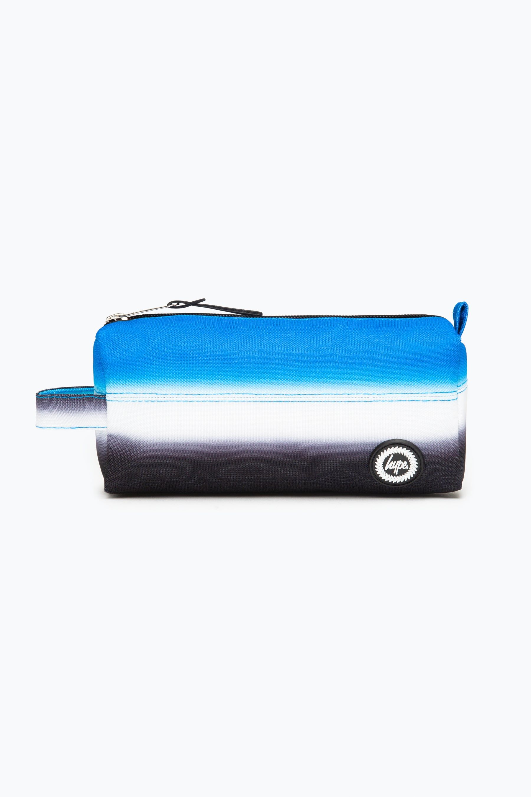 Meet the HYPE. Black Blue Pencil Case. Designed in our standard unisex pencil case shape and style, a winner for everyone. A perfect home for your stationery, pencils, pens, rulers, highlighters, and even small snacks, the last packet of mini cookies, stash them in your new HYPE. pencil case. The design features our signature gradient effect in a black and blue colour palette. Finished with embossed inside lining, rubberised iconic HYPE. crest logo and grab handle. Check out the matching lunch bag and backpack to complete the set. Wipe clean only.