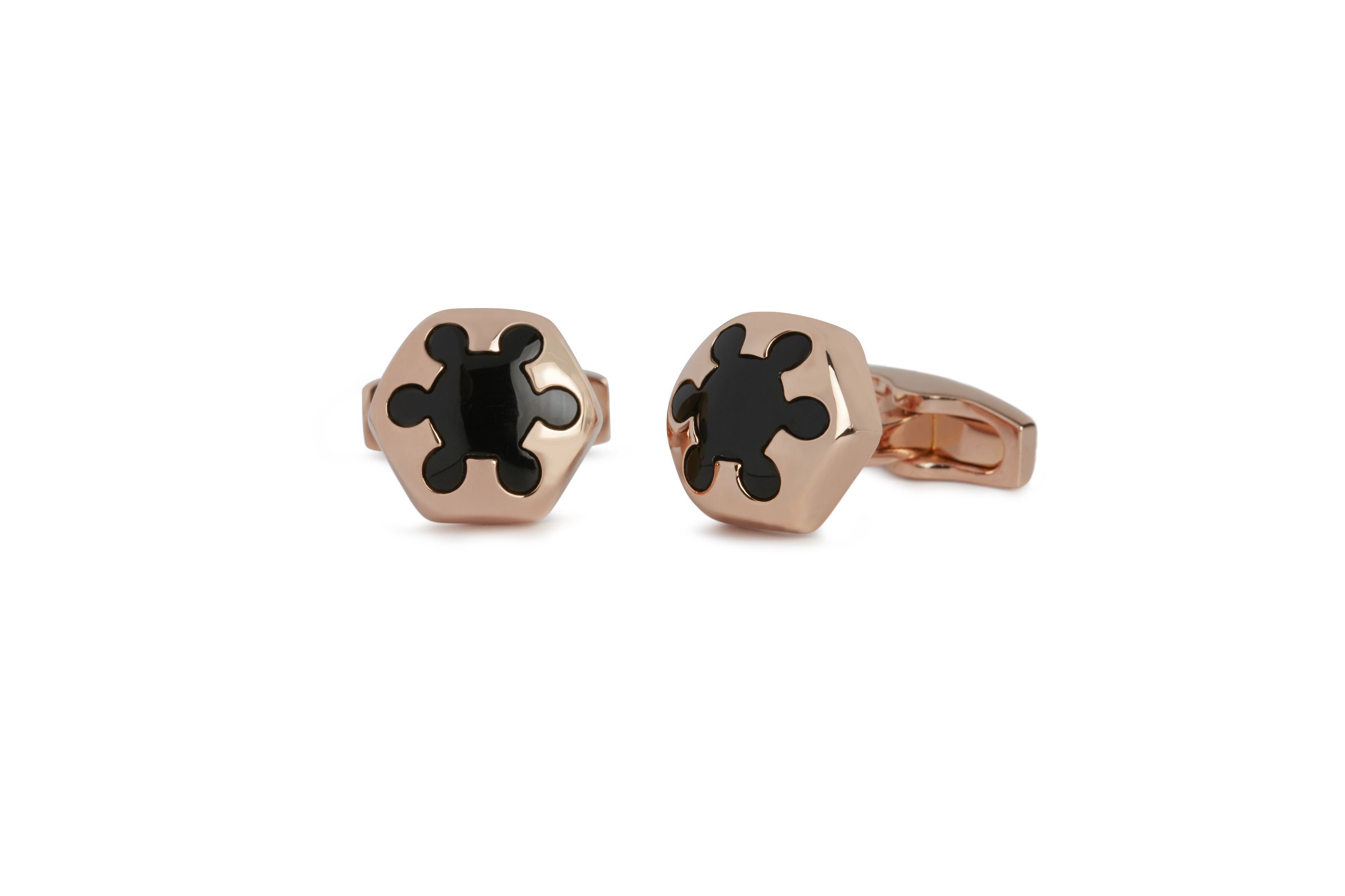 This pair of cufflinks from Simon Carter are designed with a robust, softened, domed hexagon in rose gold plated finish that is pierced by a wheeling or radiating form that organically reveals its lode of Stygian onyx within.